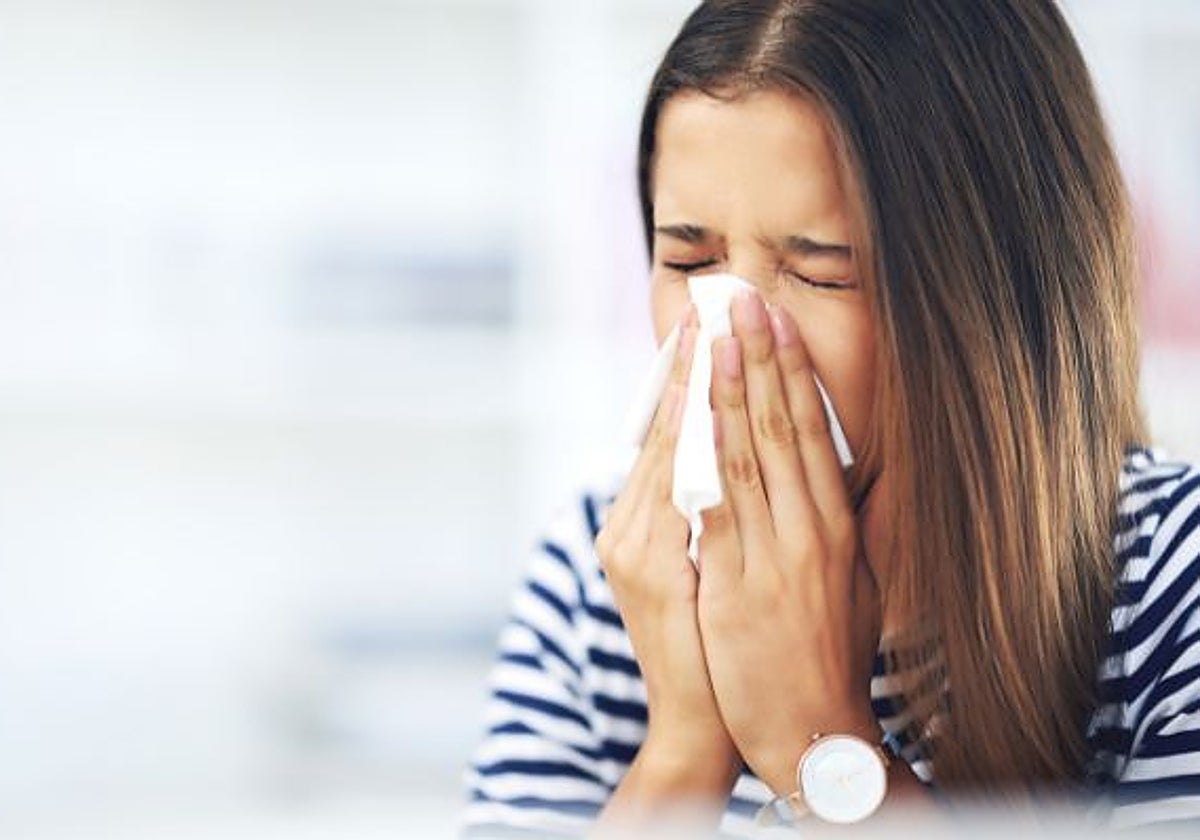Mujer sonándose la nariz con un pañuelo