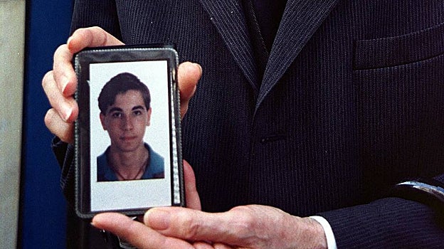 El padre de la víctima sostiene una foto de su hijo