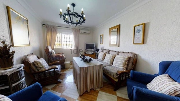 Salón de la casa con sofás, butacas y televisión