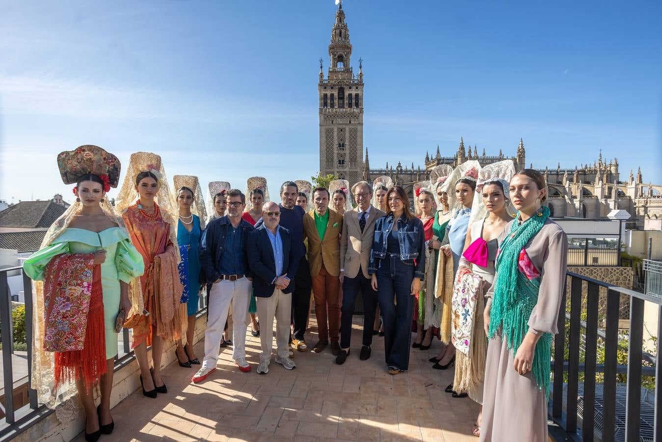 Unas jóvenes con mantilla blanca posan con la Giralda al fondo en la jornada de la Mantilla blanca