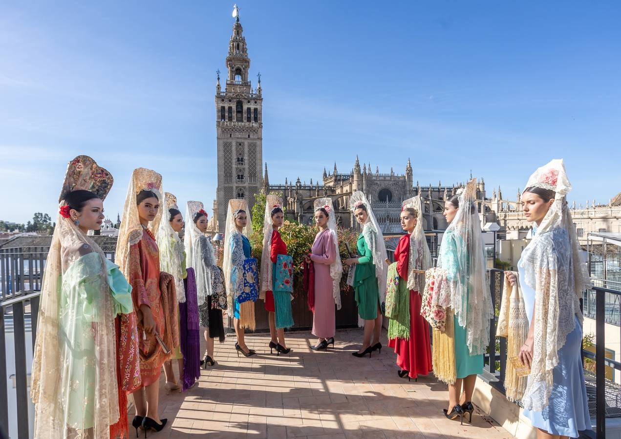 Unas jóvenes con mantilla blanca posan con la Giralda al fondo en la jornada de la Mantilla blanca