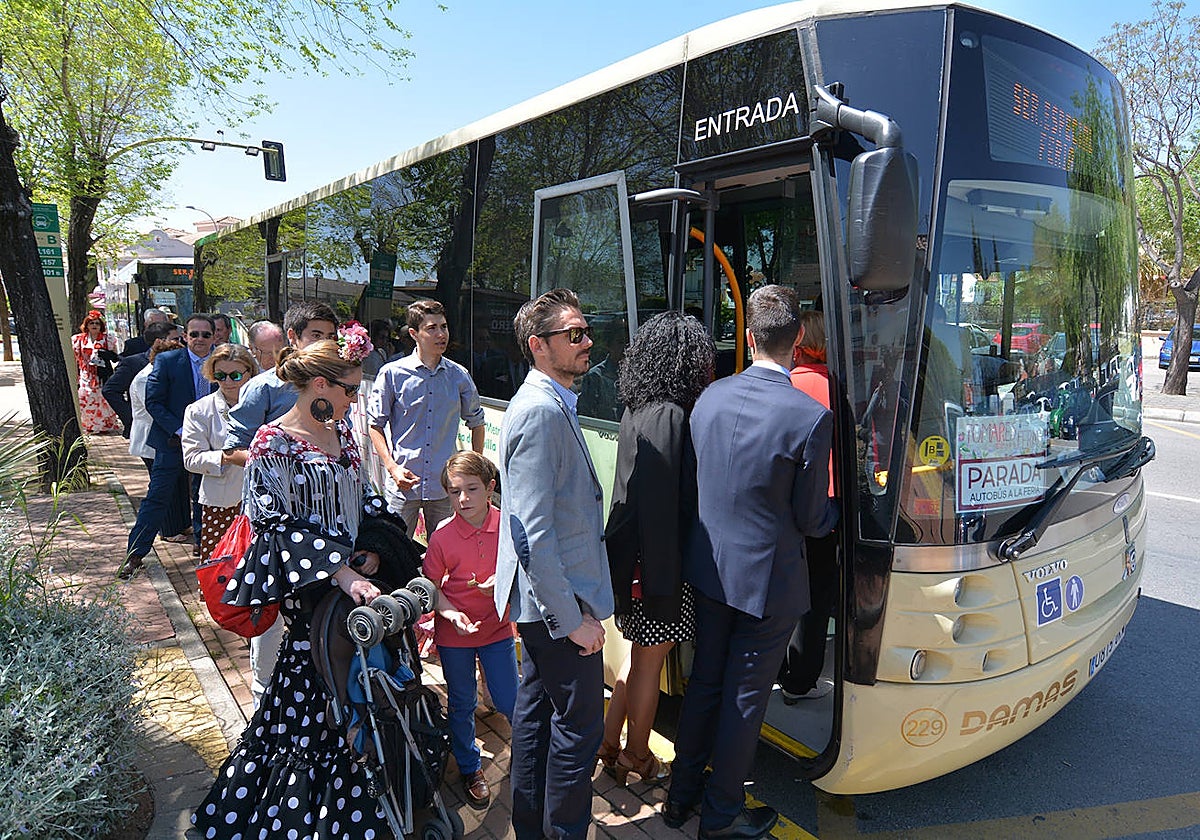 Usuarios se montan en un autobús especial de Tomares para acudir a la feria