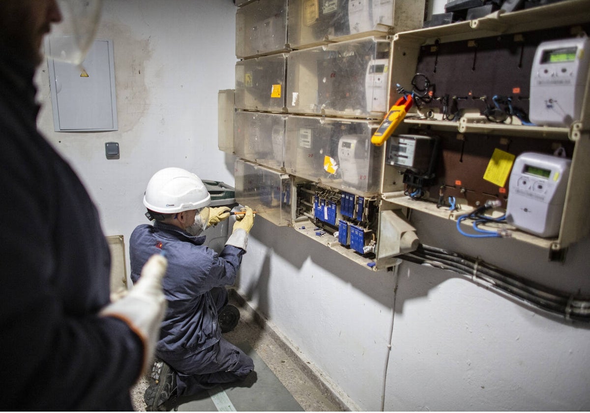 Operarios en Endesa inspeccionan el cuadro de contadores en un edificio de las Tres Mil Viviendas