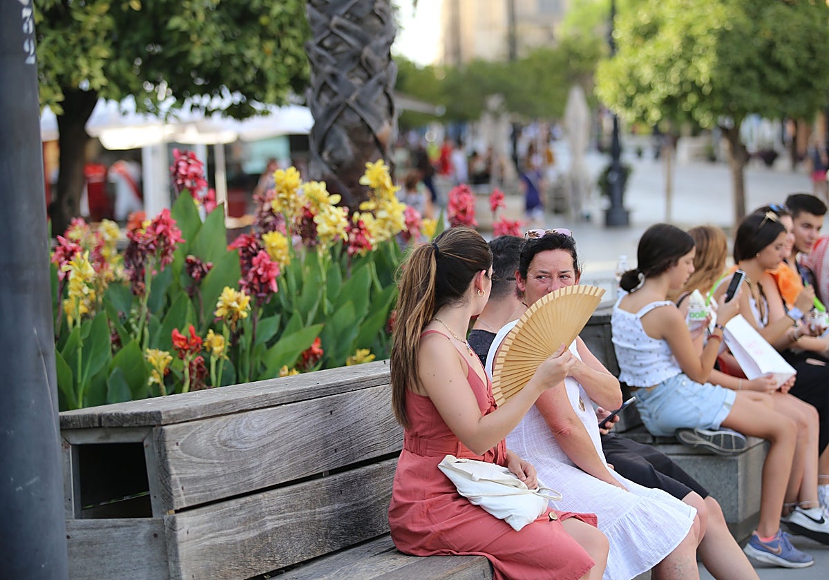 Fotografía de una mujer abanicándose por las altas temperaturas en Sevilla