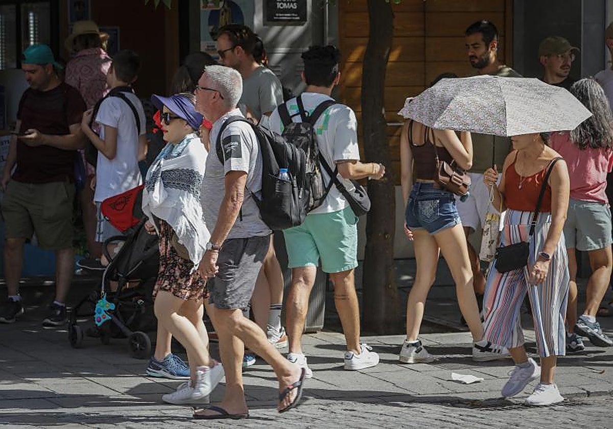 Turistas con paraguas protegiéndose del calor y del sol en la última ola de calor