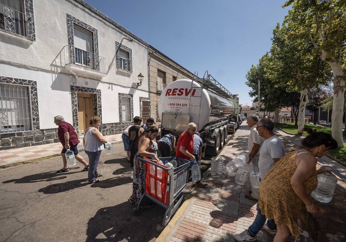 Un grupo de personas rellenan botellas de agua gracias a un camión cisterna