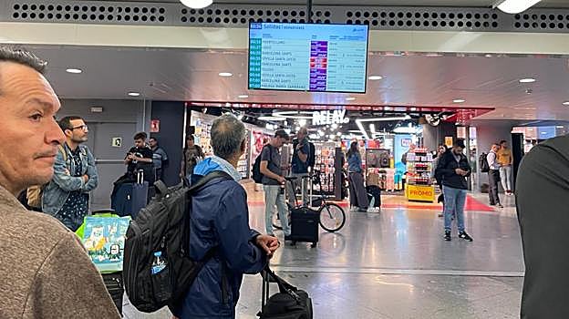 Decenas de pasajeros viendo las pantallas informativas en Atocha