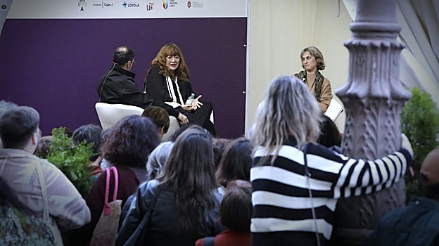 En la imagen, una asistente subida a una farola durante el acto de Isabel Coixet y Sara Mesa