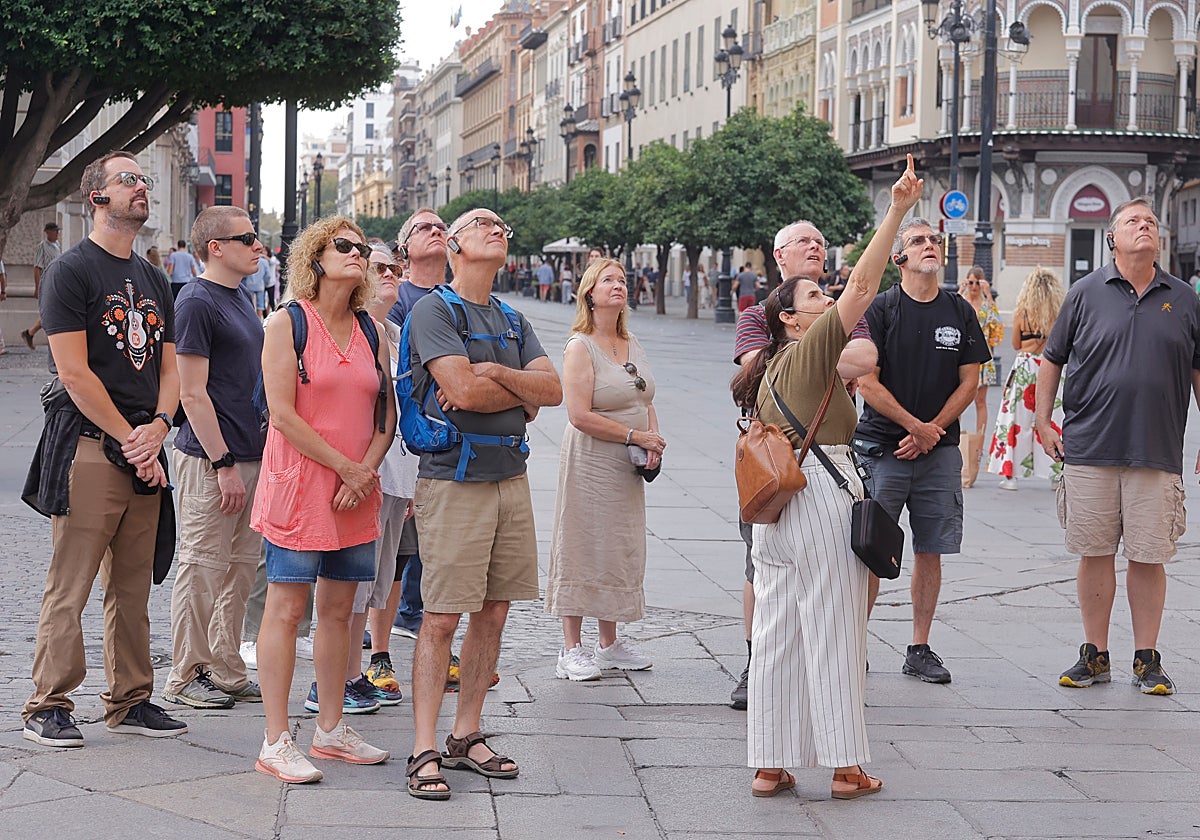 Un grupo de turistas junto a una guía en la Avenida de la Constitución