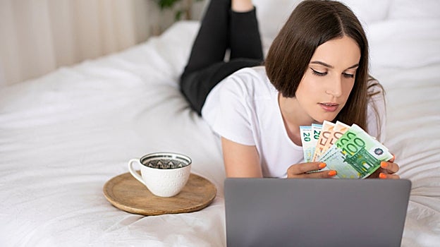 Imagen de archivo de una trabajadora autónoma sosteniendo unos billetes