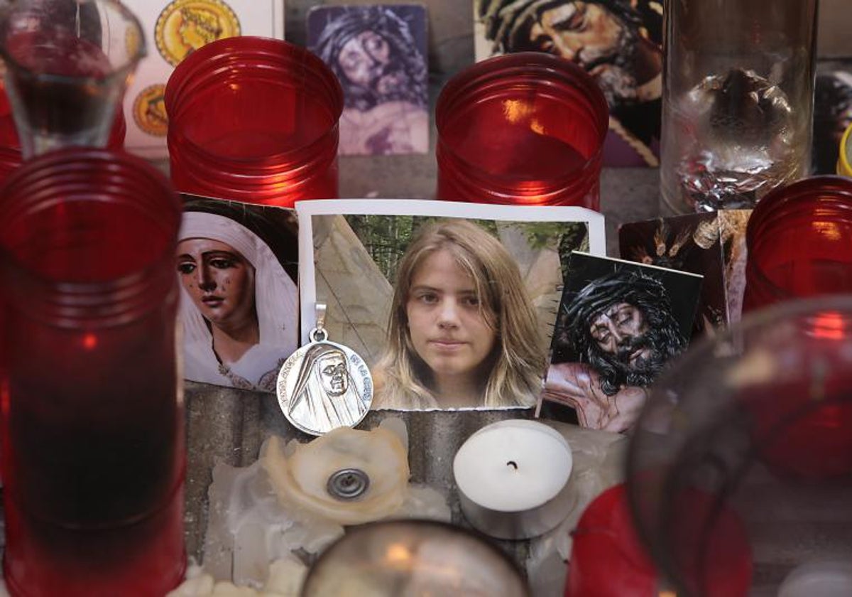 Una imagen de Marta junto a velas y estampas de imágenes sagradas sevillanas