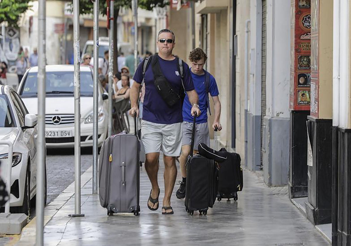 Dos turistas con maletas en el Casco Histórico de Sevilla