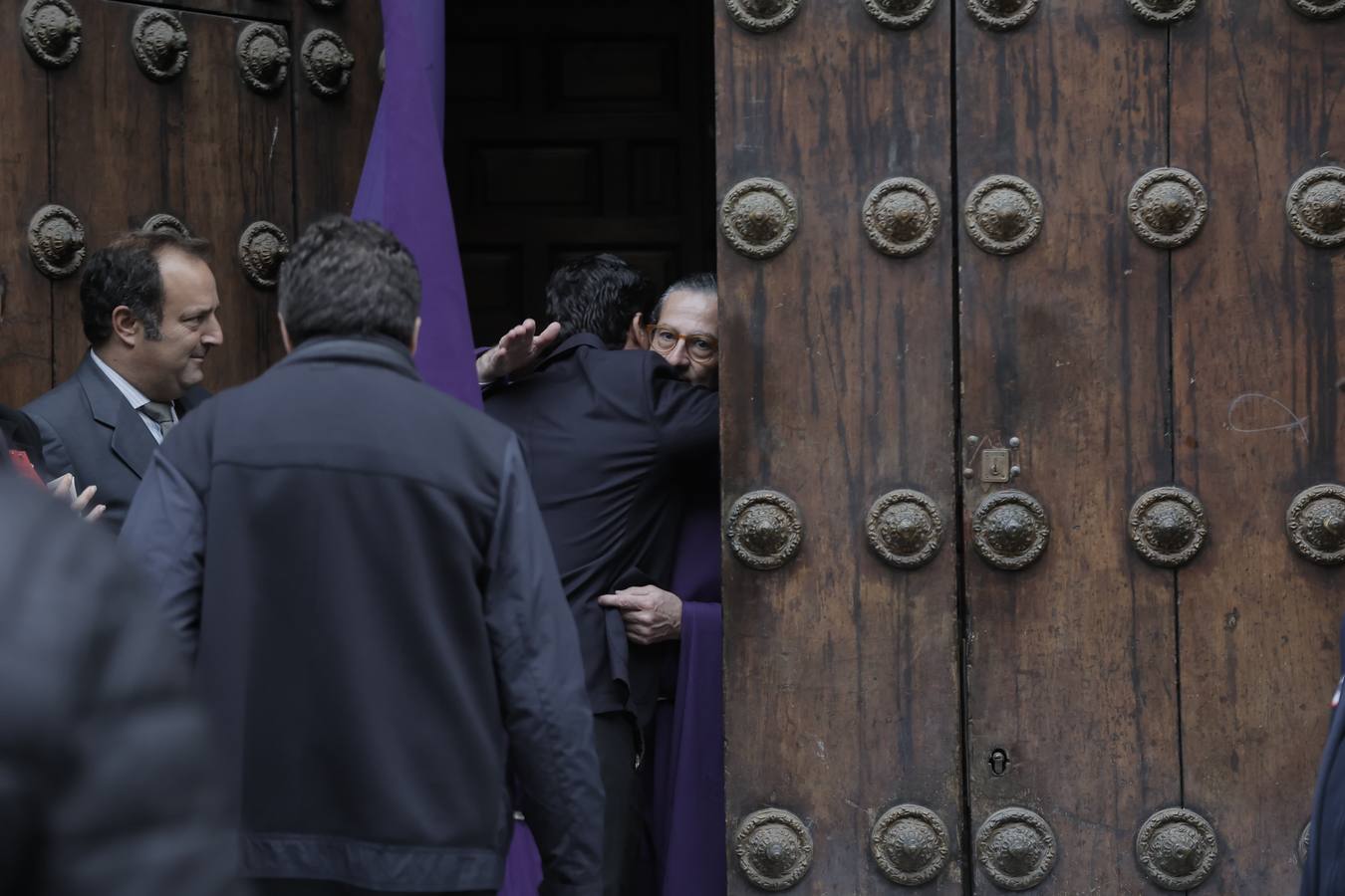 Nazarenos y costaleros se lamentan a las puertas de la iglesia de la Anunciación tras la decisión de no salir de la hermandad del Valle