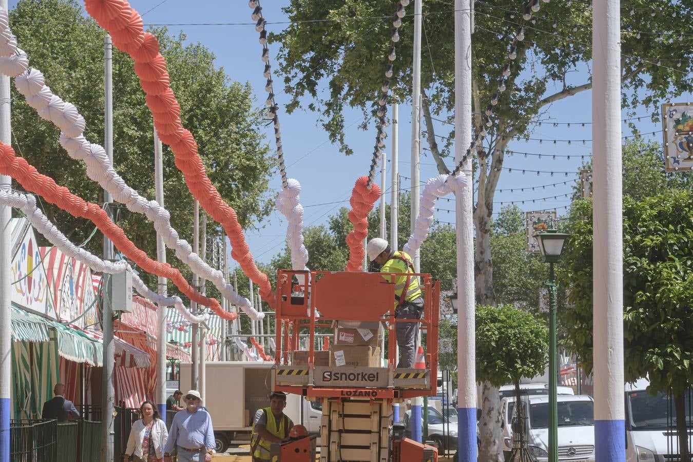 Operarios colocan los farolillos que se estropearon durante la lluvia de esta semana