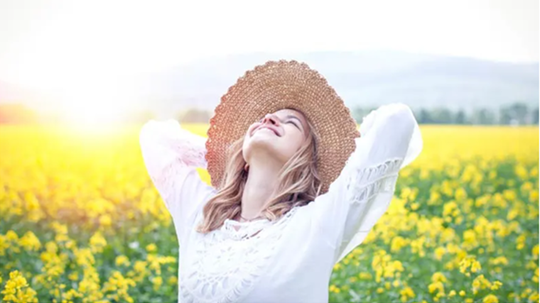 Imagen de archivo de una mujer alegre en el campo, durante un día de primavera