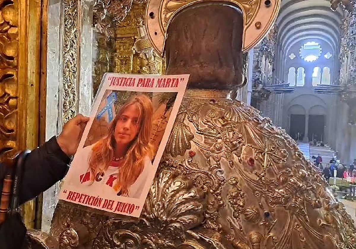 El abuelo pasó uno de los carteles reivindicativos con la foto de Marta por el manto del Santo en la catedral de Santiago
