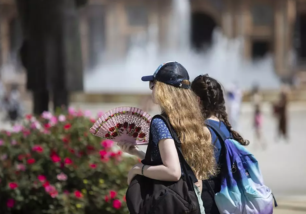 Imagen de archivo de dos mujeres caminando durante un día soleado en Sevilla por la Plaza de España