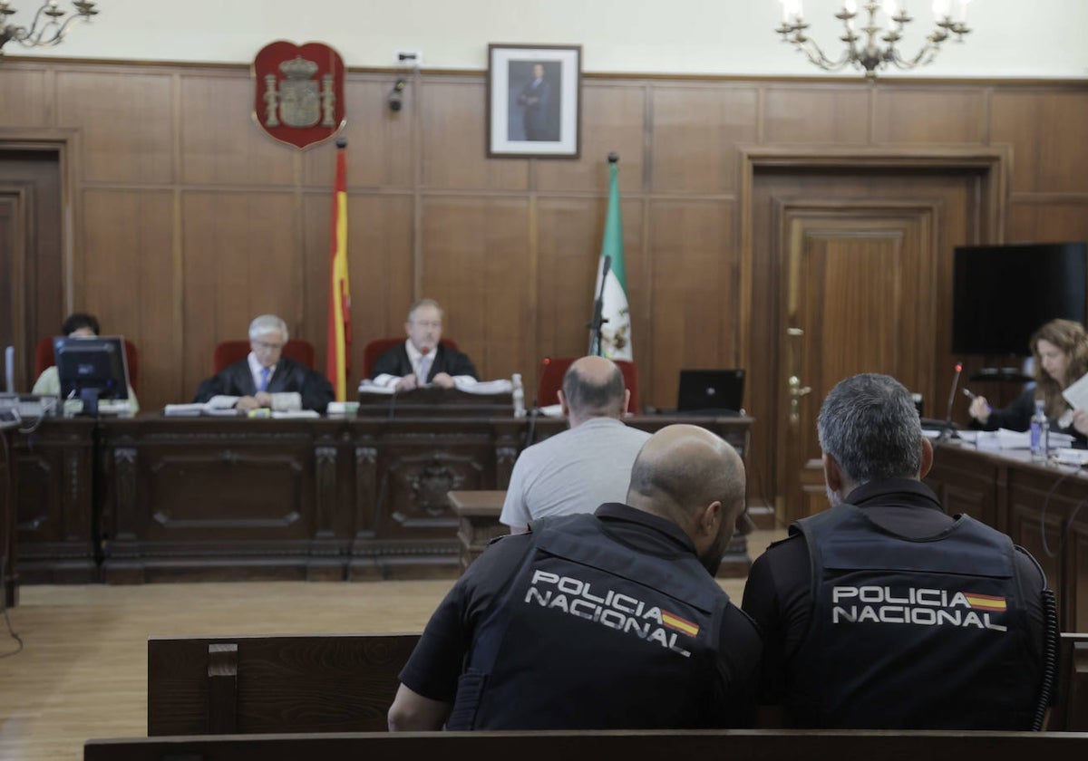 El acusado, custodiado por dos agentes, durante la primera sesión del juicio con jurado