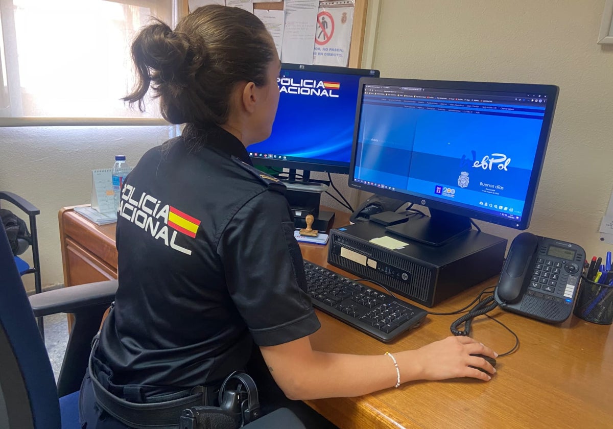 Imagen de archivo de una policía con un ordenador rastreando información