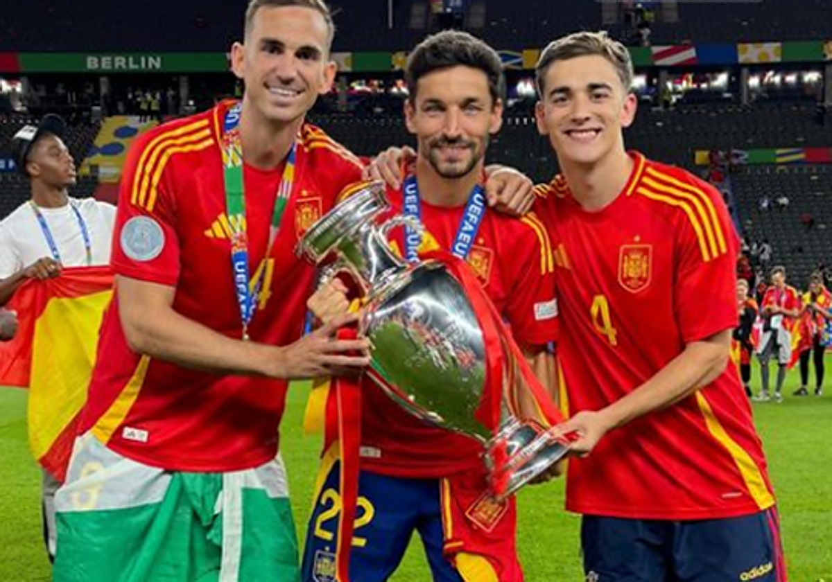 Fabián, Jesús Navas y Gavi, los tres jugadores de Los Palacios, posan con la Eurocopa lograda por la Selección el pasado domingo