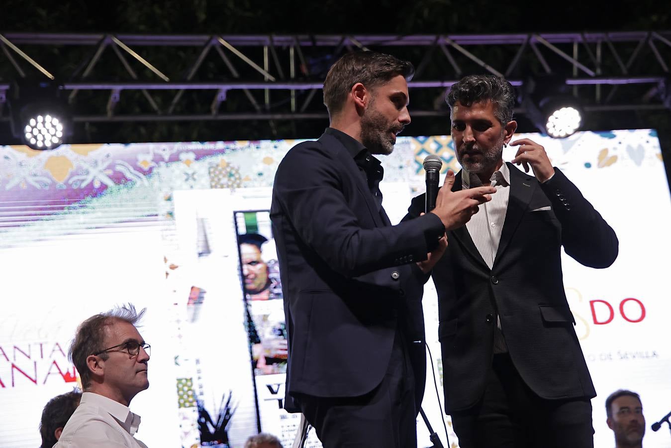 La calle Betis ya está encendida para celebrar su Velá tras el pregón de José Yélamo y la actuación de Silvia Pantoja y Arcángel