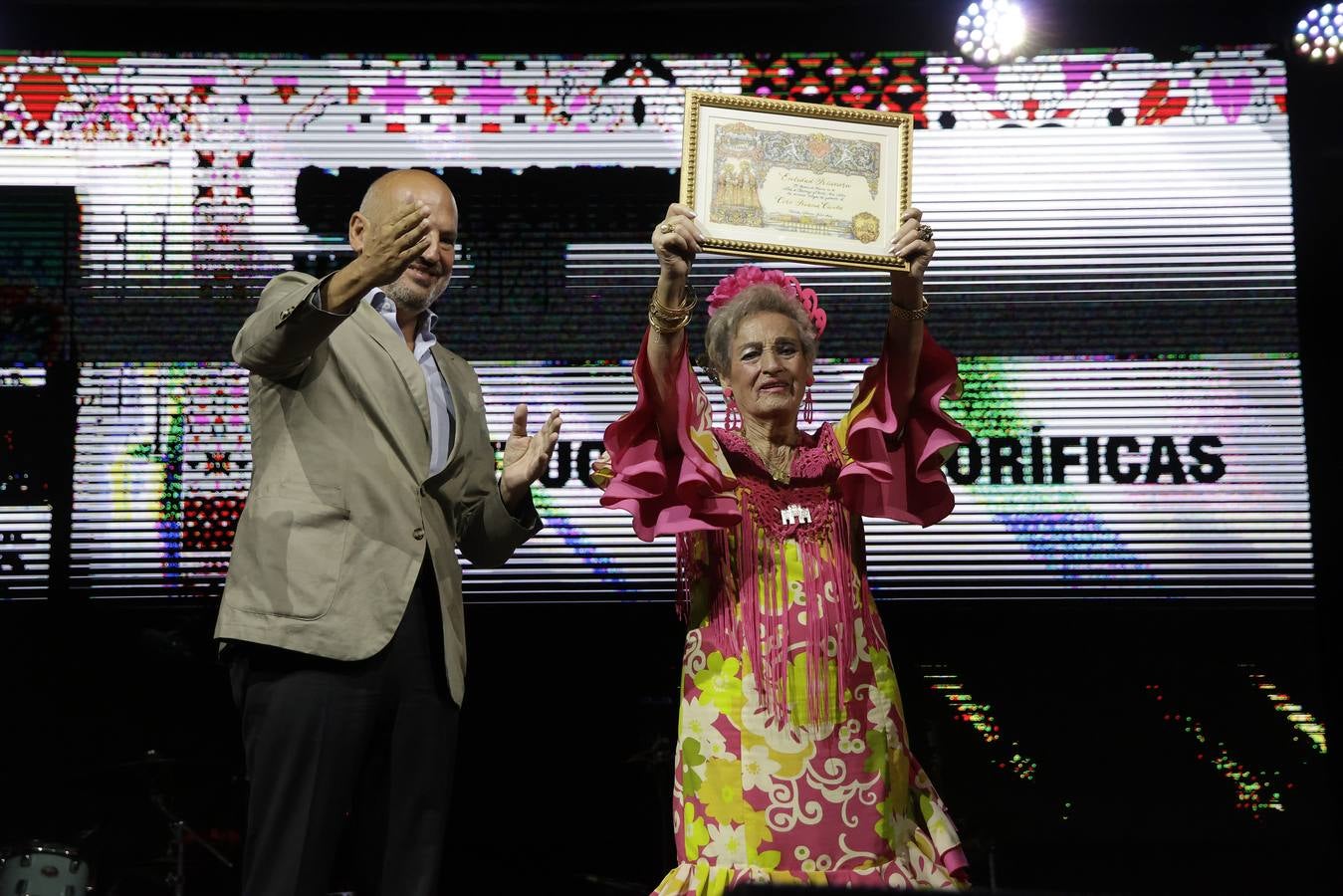El alcalde, José Luis Sanz, entregó los galardones de la Velá de Santa Ana junto con otros representantes municipales. En la imagen, galardón al Coro Triana canta