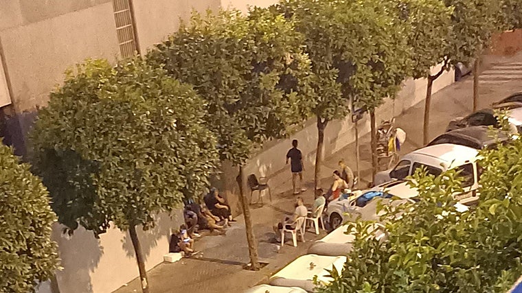 Los okupas sentados en la acera de enfrente del edificio