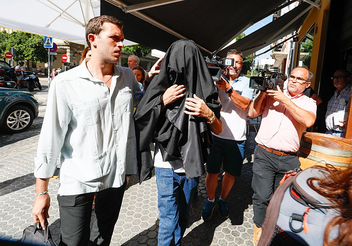 Candi, el transgénero condenado por maltrato a su expareja, sale de los juzgados ocultando su rostro con una toga