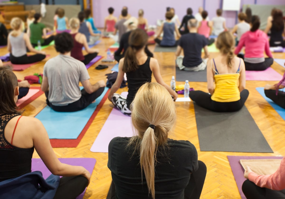 Varios alumnos hacen clase de yoga en una imagen de archivo