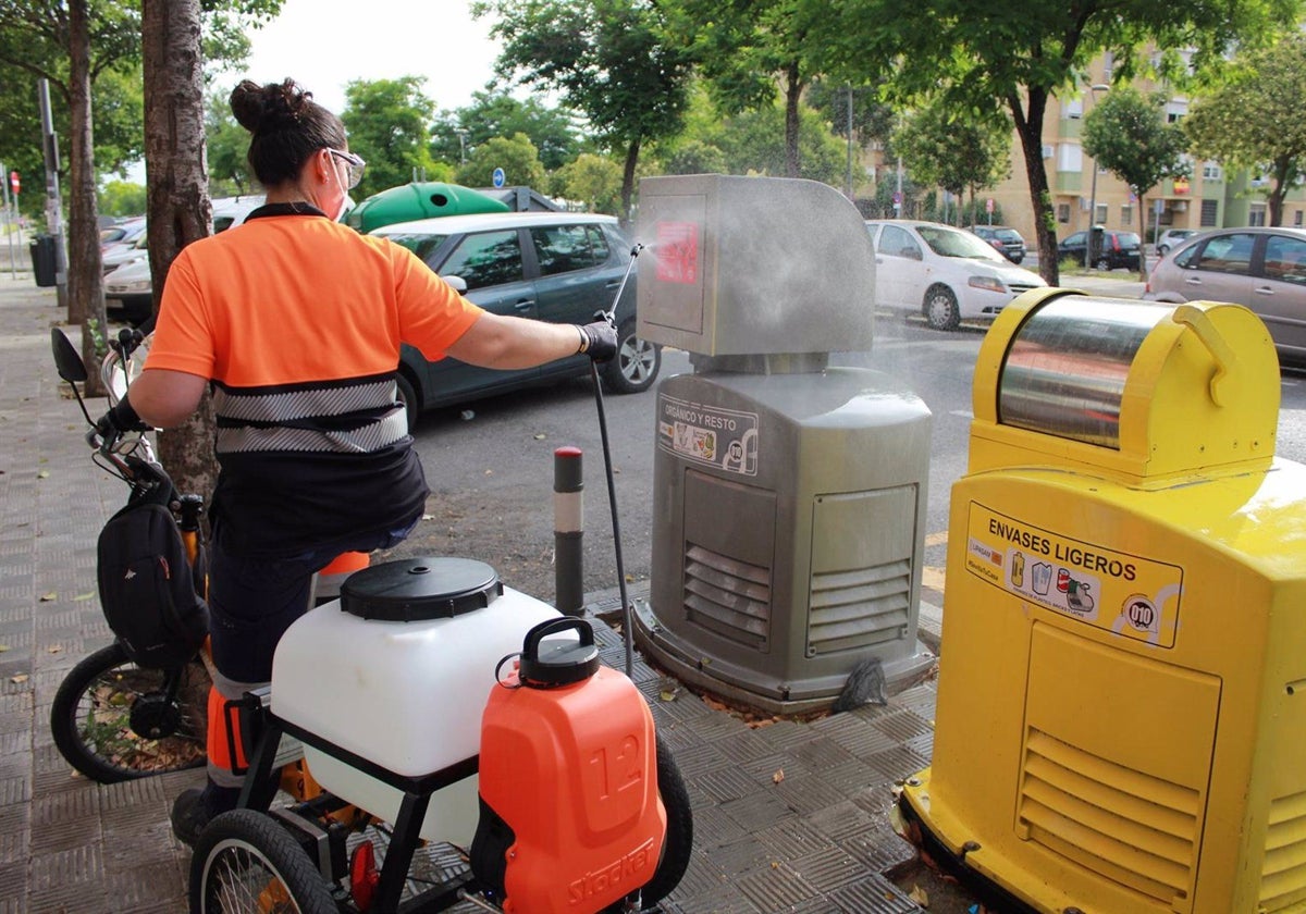 Una operaria de Lipasam, en un triciclo eléctrico adaptado para desinfectar contenedores de recogida neumática