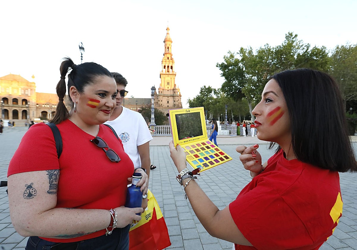 Dos jóvenes vestidas con los colores de la bandera en la Plaza de España