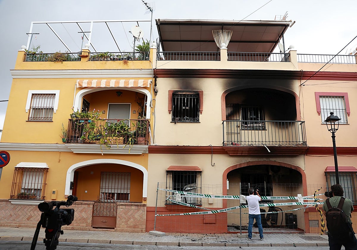 Varios redactores gráficos graban la fachada de la casa incendiada, precintada por la Guardia Civil