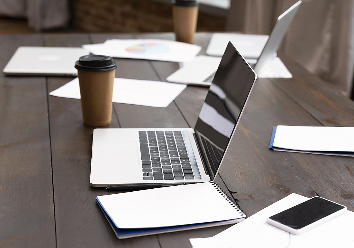 Una mesa con ordenadores portátiles