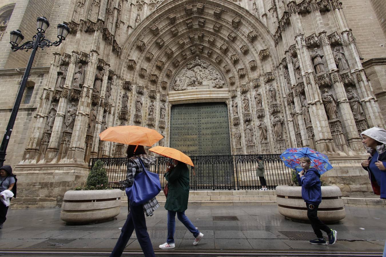 Los paraguas han inundado las calles del Centro de Sevilla durante el día de la Fiesta Nacional