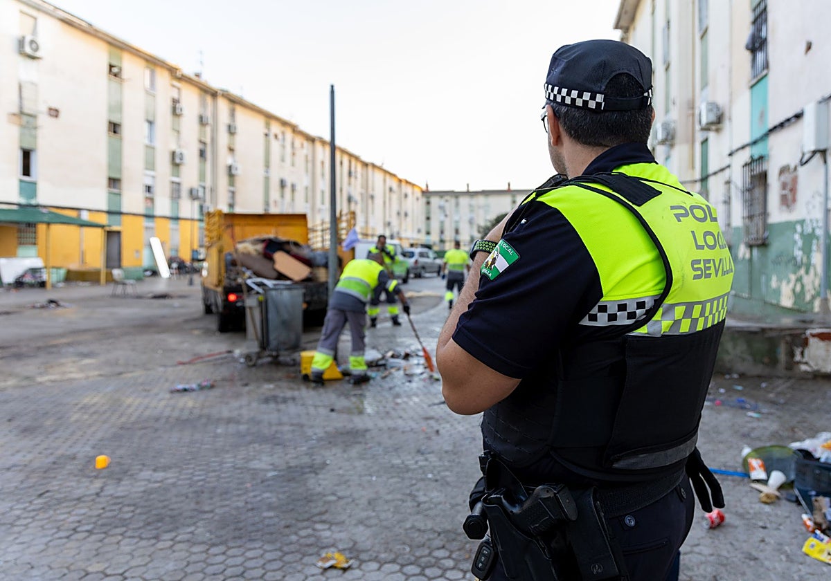 Operarios de la limpieza haciendo su labor ante la presencia de policías