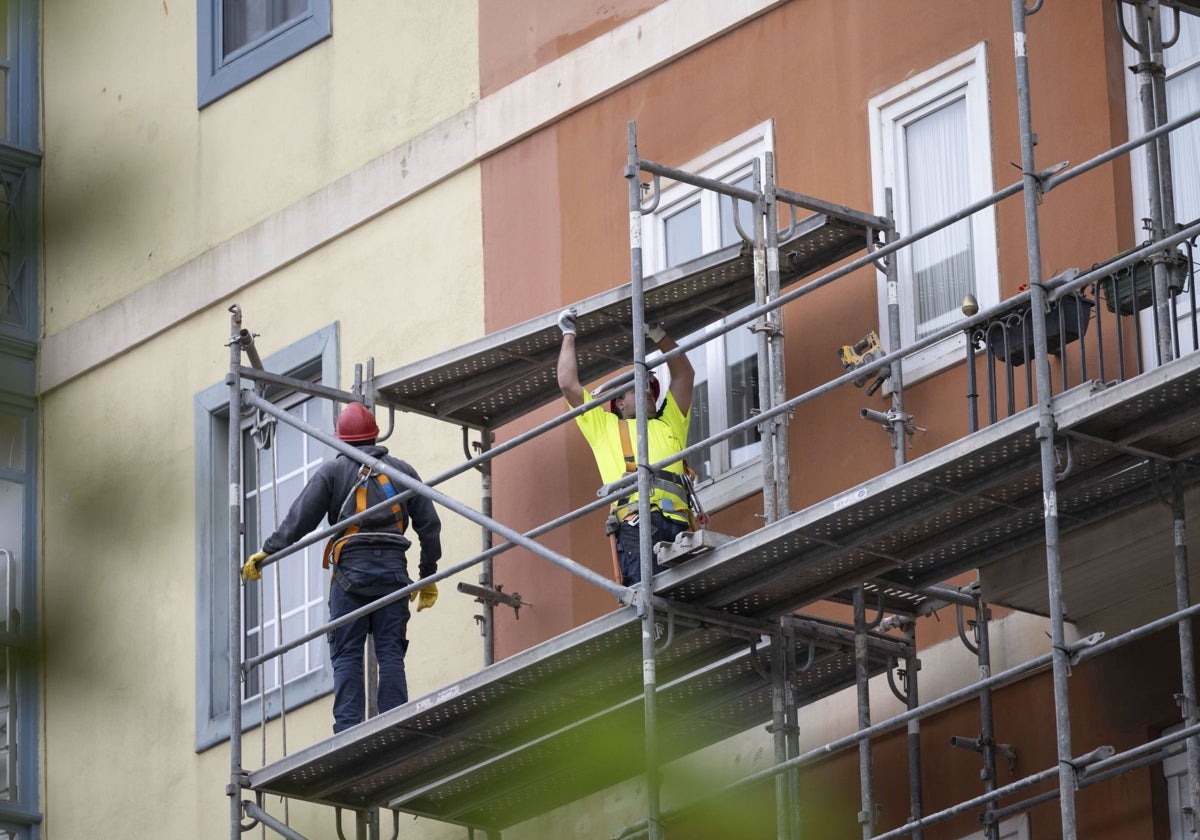 Varios trabajadores en el andamio de una obra