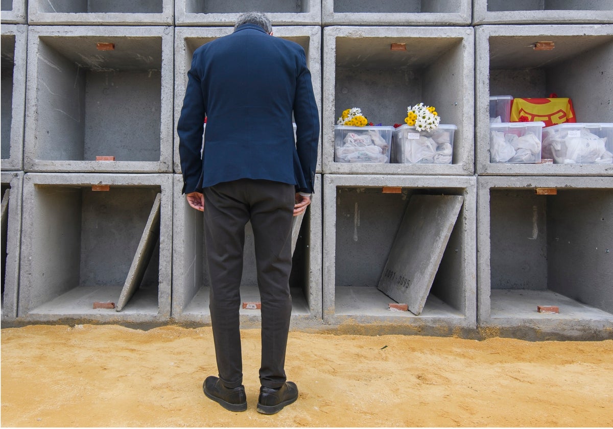 Una persona junto a uno de los nichos del cementerio de Sevilla