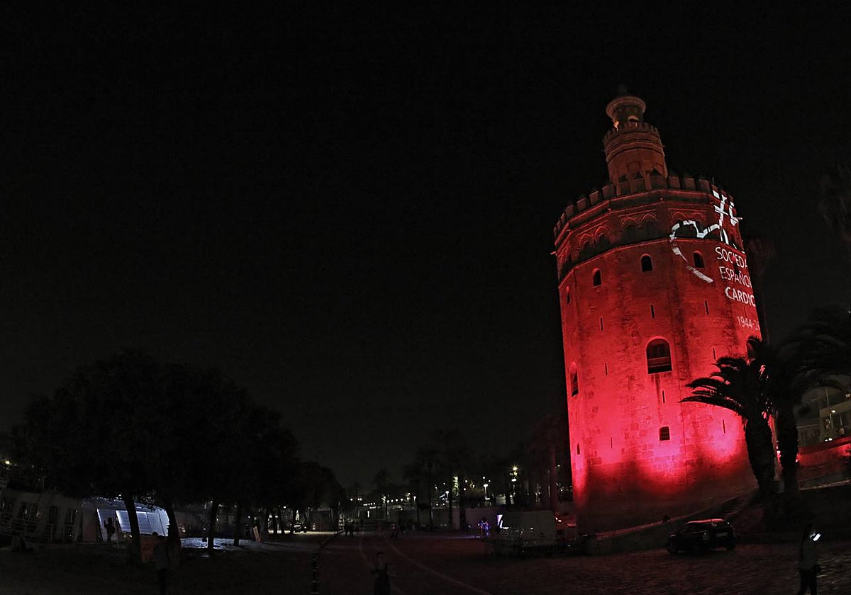 Imagen de archivo de la Torre del Oro iluminada de rojo con motivo del 75 aniversario de la AECC