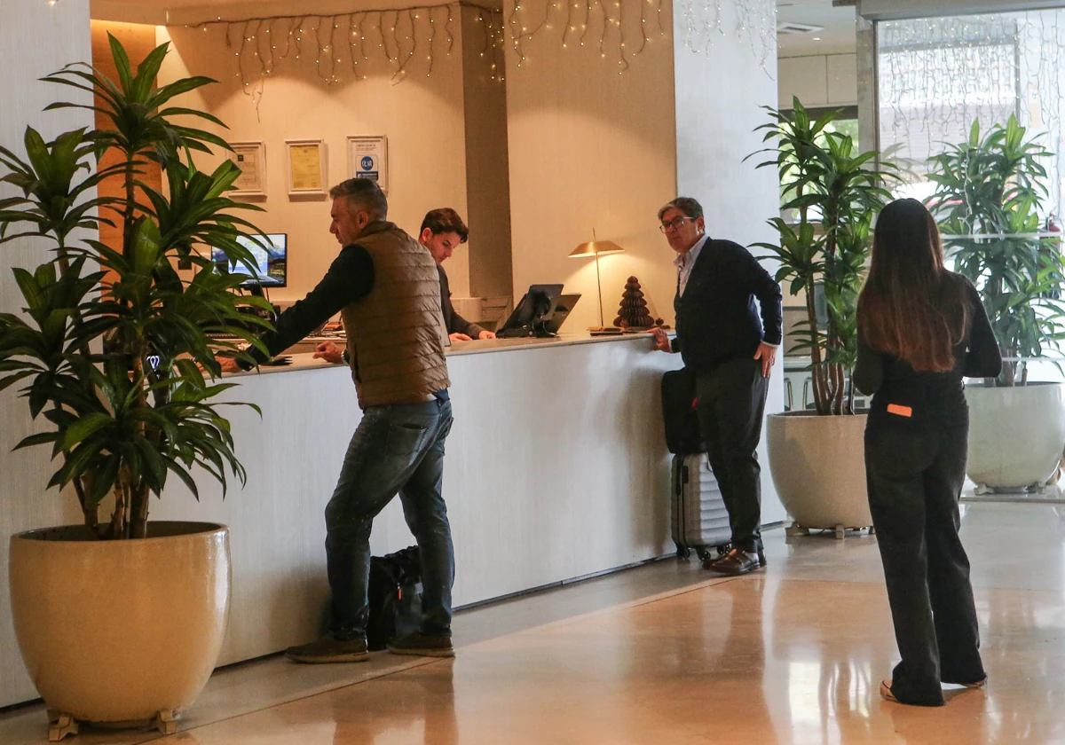 Varios clientes esperan para registrarse en un hotel de Sevilla