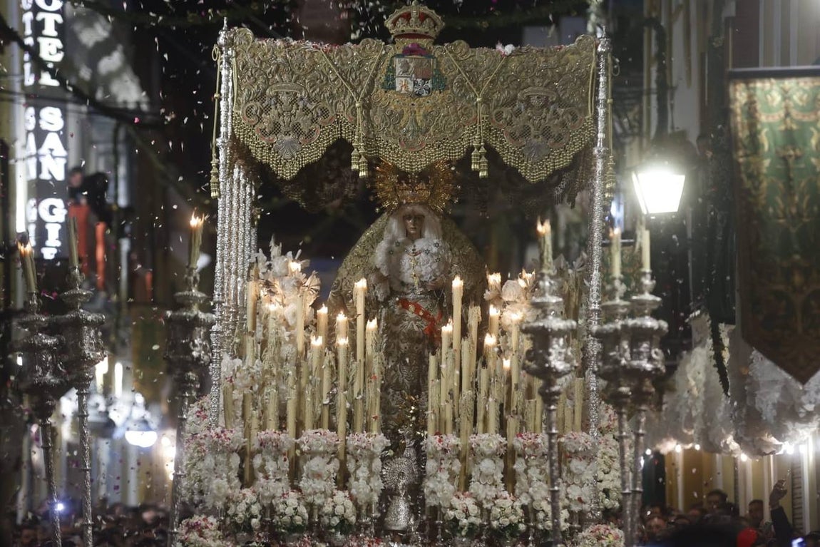 Discurrir de la Macarena por una abarrotada calle Parras ya de madrugada