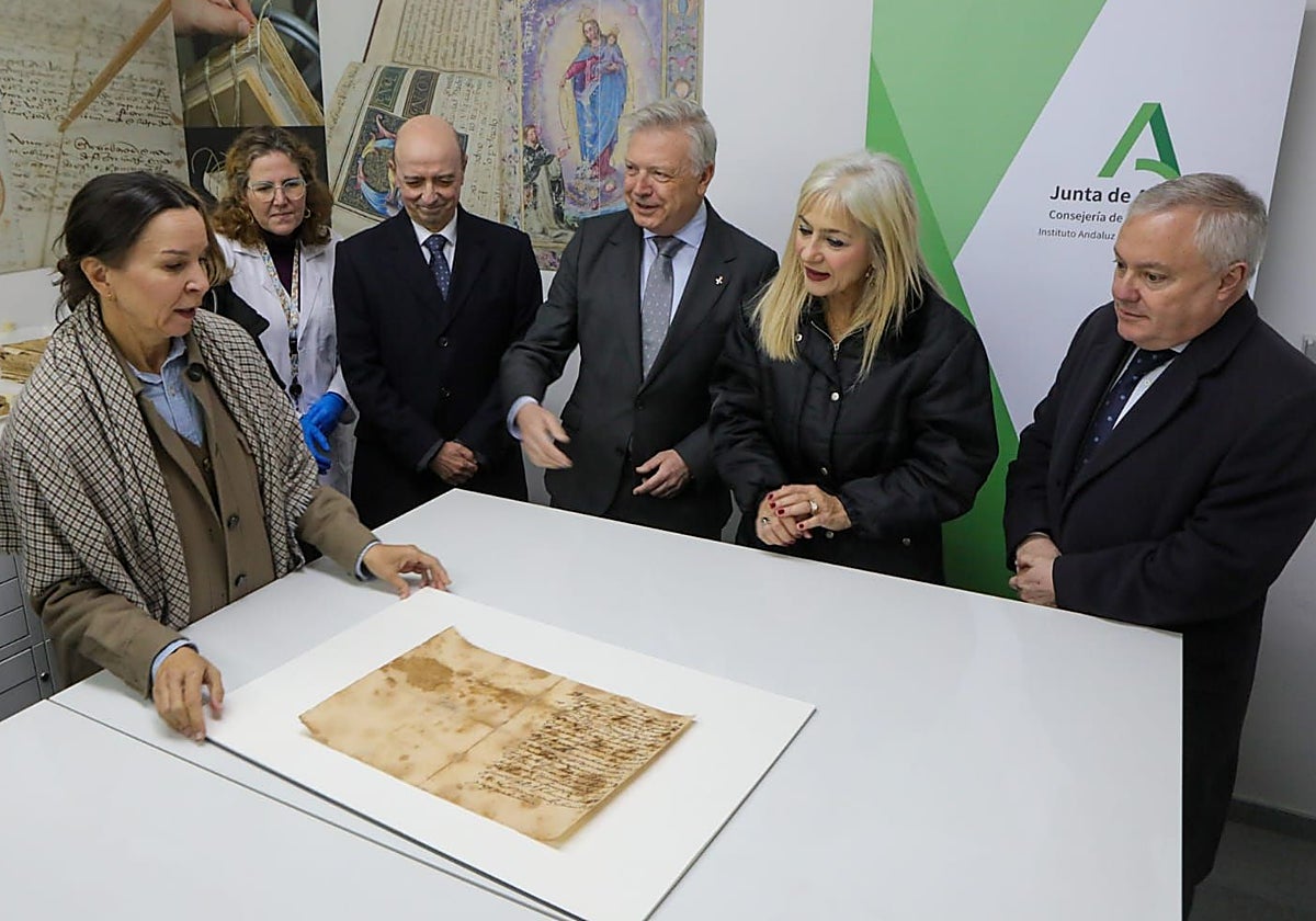 La consejera de Cultura, el hermano mayor y el teniente del Santo Entierro, con los restauradores