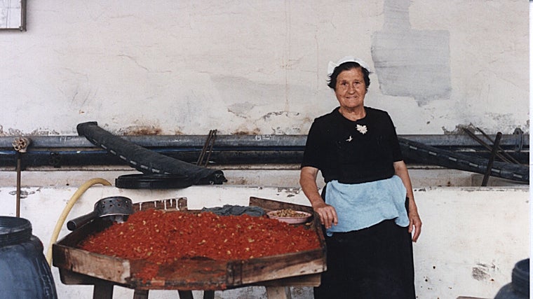 Una de las trabajadoras de la fábrica La Palmera junto al tapis donde elaboraban los aliños