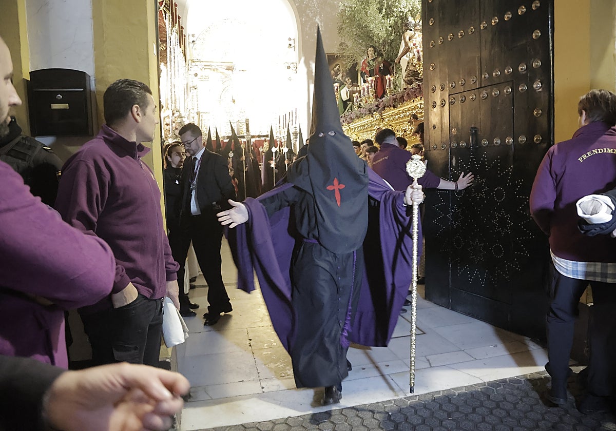 Un nazareno de los Panaderos en la puerta de la capilla impidiendo el paso el pasado Miércoles Santo