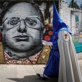 Nazarenos de la Hiniesta pasan delante de un mural de Francisco Palacios 'El Pali'