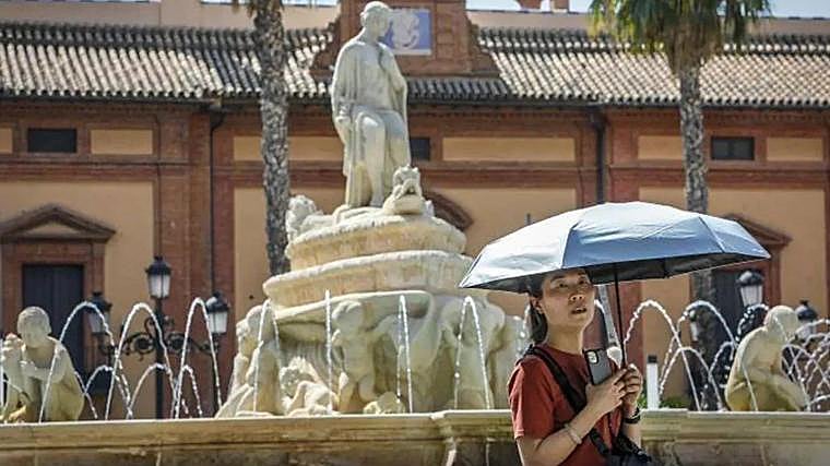 Una mujer se protege del sol en Sevilla
