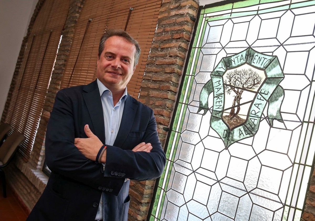 Antonio Conde posa junto a una cristalera del ayuntamiento mairenero