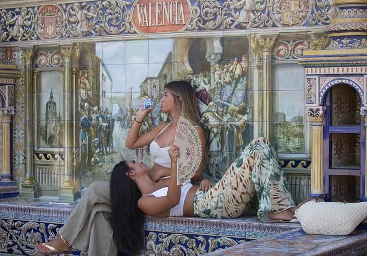 Dos jóvenes se refrescan en la Plaza de España ante el calor