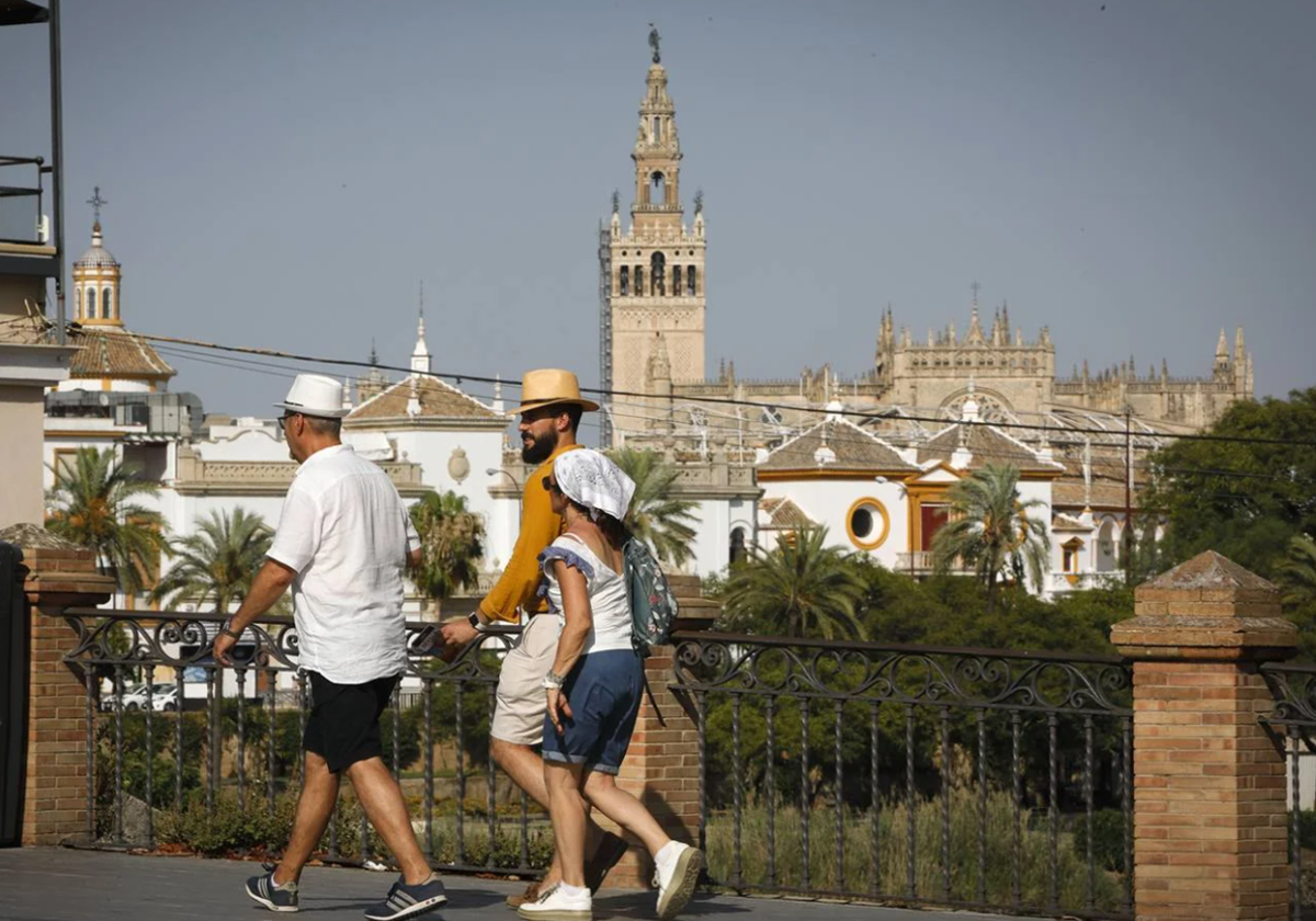 Personas dispuestas a cruzar el Puente de Triana en una jornada de ola de calor en Sevilla del pasado verano