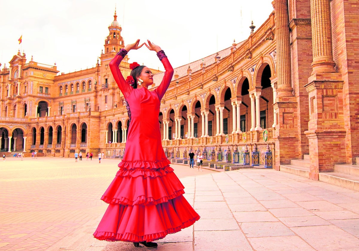 Una mujer vestida de flamenca en la Plaza de España de Sevilla, una de las estampas más turísticas