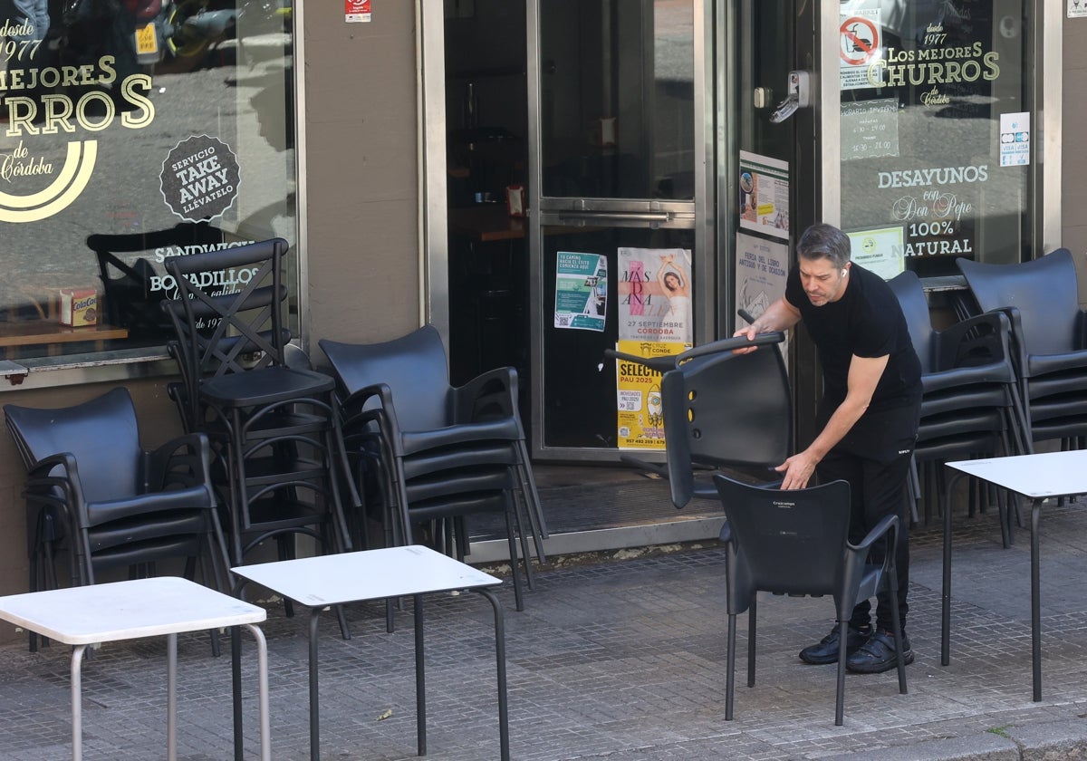 Un trabajador recoge las sillas de un establecimiento